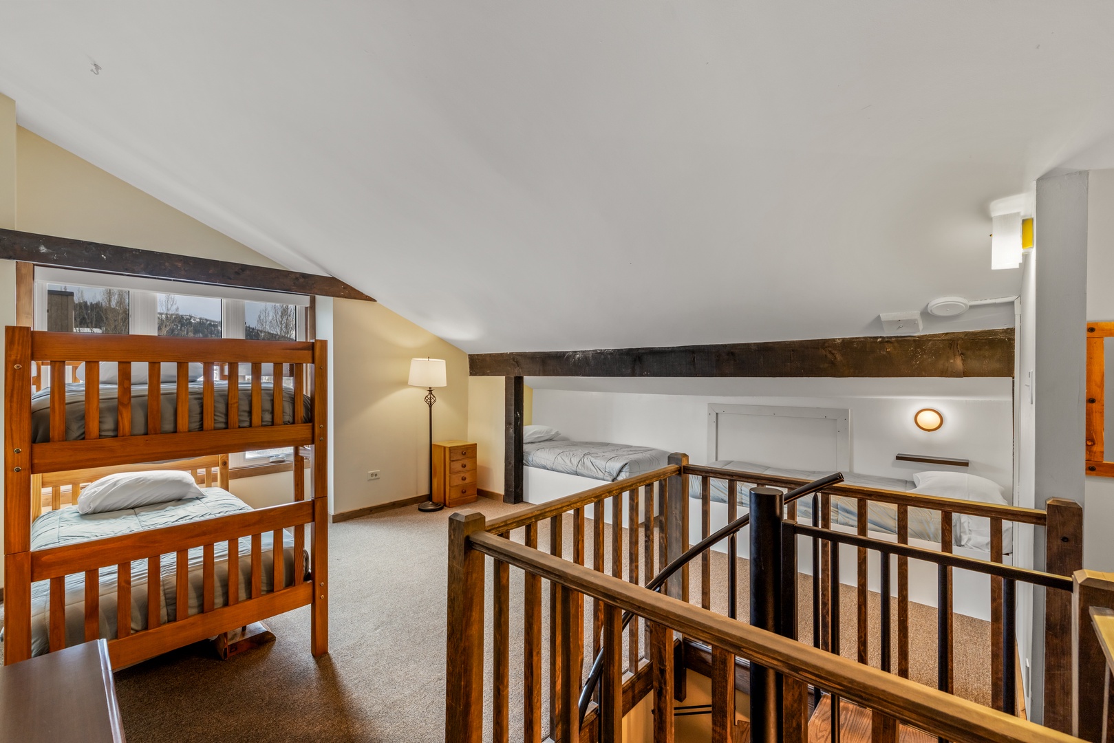 Sleep peacefully in your charming loft bedroom with rustic wooden beams, cozy bunk beds, and built-in reading nooks for quiet moments.