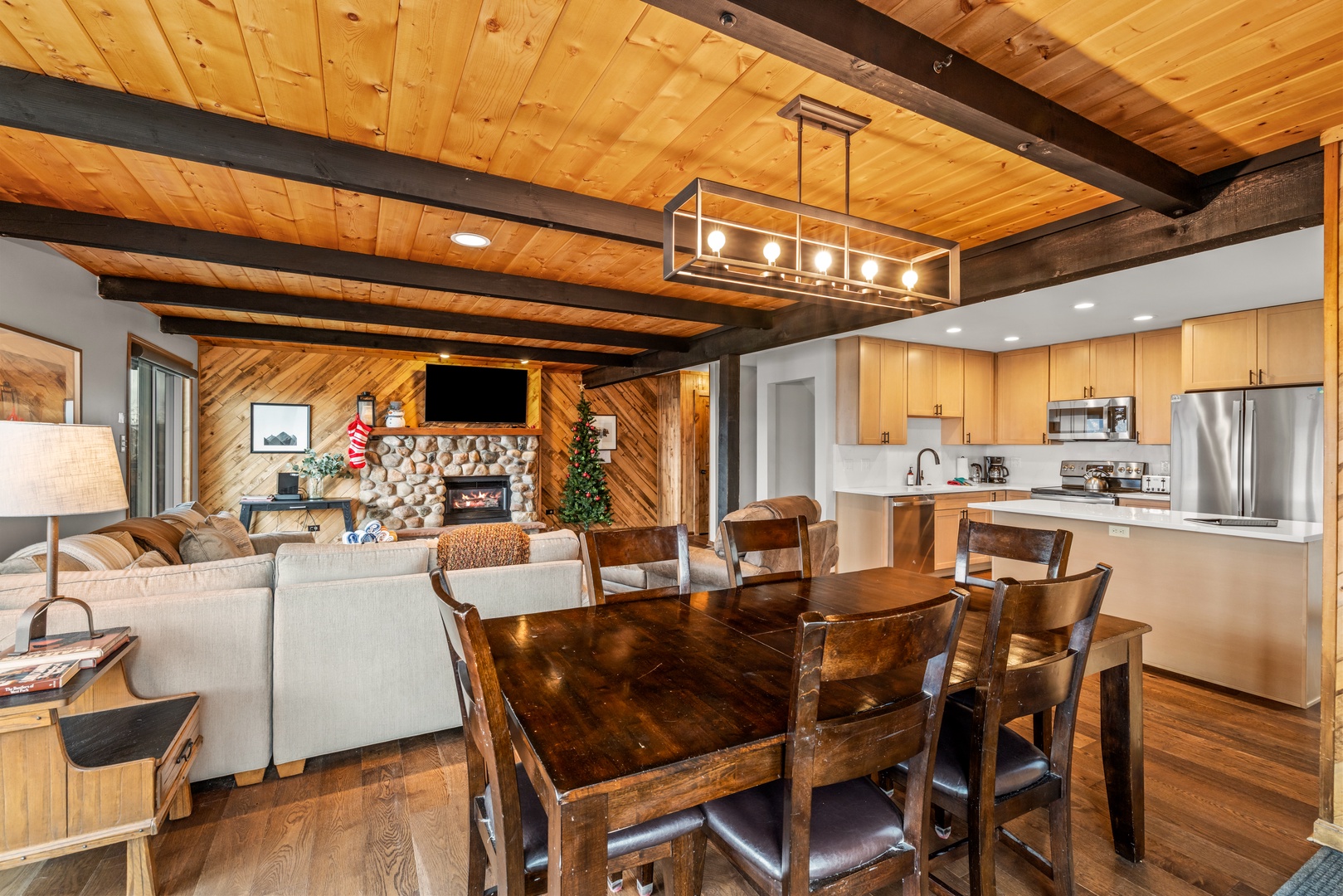 Gather around your rustic dining table while soaking in the warmth of exposed beams and crackling fireplace in this open mountain retreat.