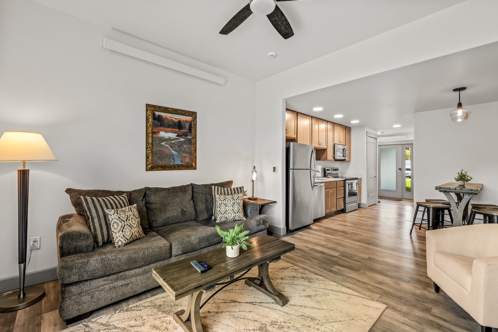 Relax in your open-concept living space with stylish furnishings, warm wood-look floors, and a fully-equipped kitchen just steps away—perfect for unwinding after a day of adventure.