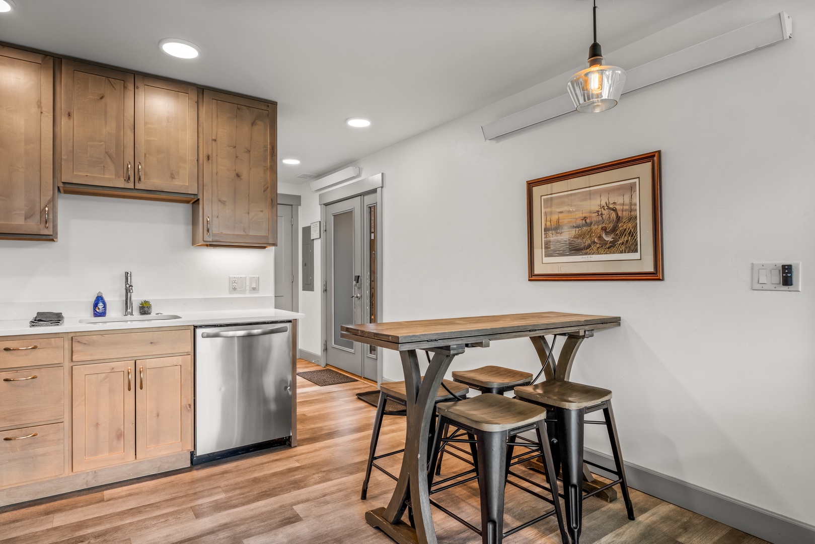 You'll love gathering at the handcrafted wood dining table, perfect for morning coffee or evening meals. The sleek kitchenette features modern appliances and warm wood cabinetry, creating an inviting space for your stay.