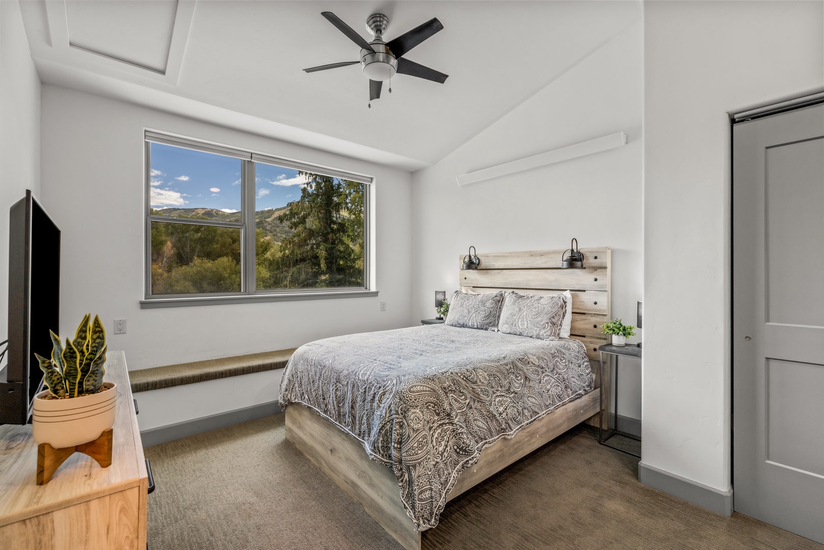 Drift off beneath the gentle hum of the ceiling fan while mountain views frame your mornings through the bright bedroom window.