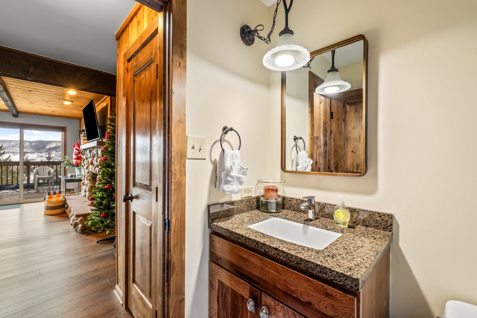 Your private bathroom features warm wood vanity, granite countertops, and stylish pendant lighting for a luxurious retreat.