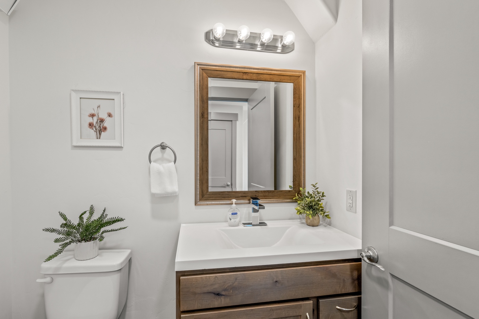 Freshen up in your bright, welcoming bathroom featuring a stylish wood-framed vanity, tasteful lighting, and thoughtful touches that make you feel right at home.