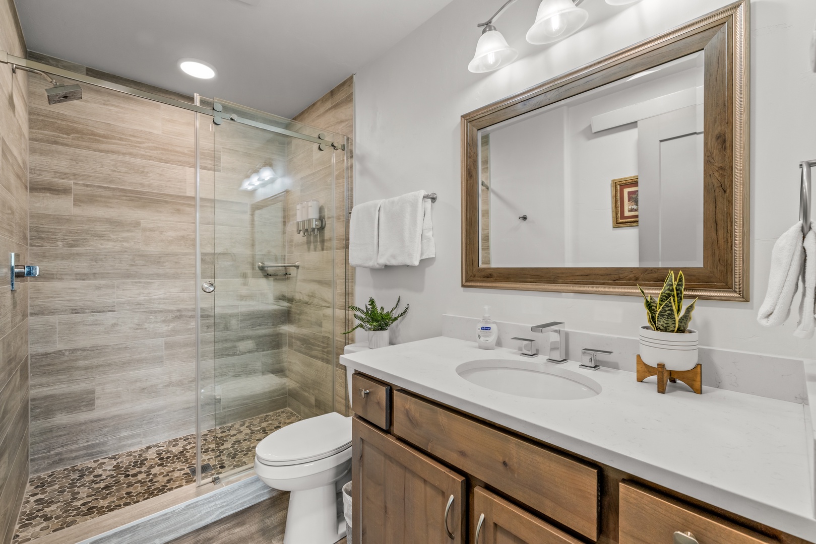 Refresh in your modern bathroom featuring a spacious walk-in shower, natural wood tones, and thoughtful design that blends style with comfort.