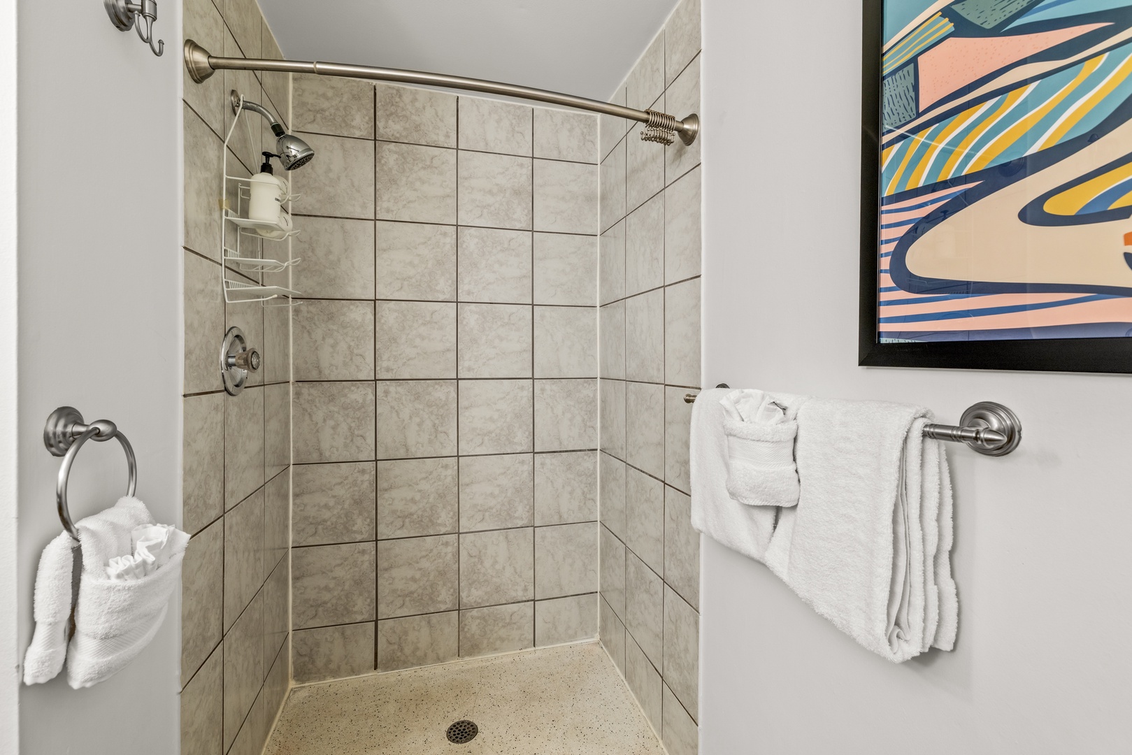 Step into your private tiled shower with crisp white towels ready for your use after a refreshing rinse.