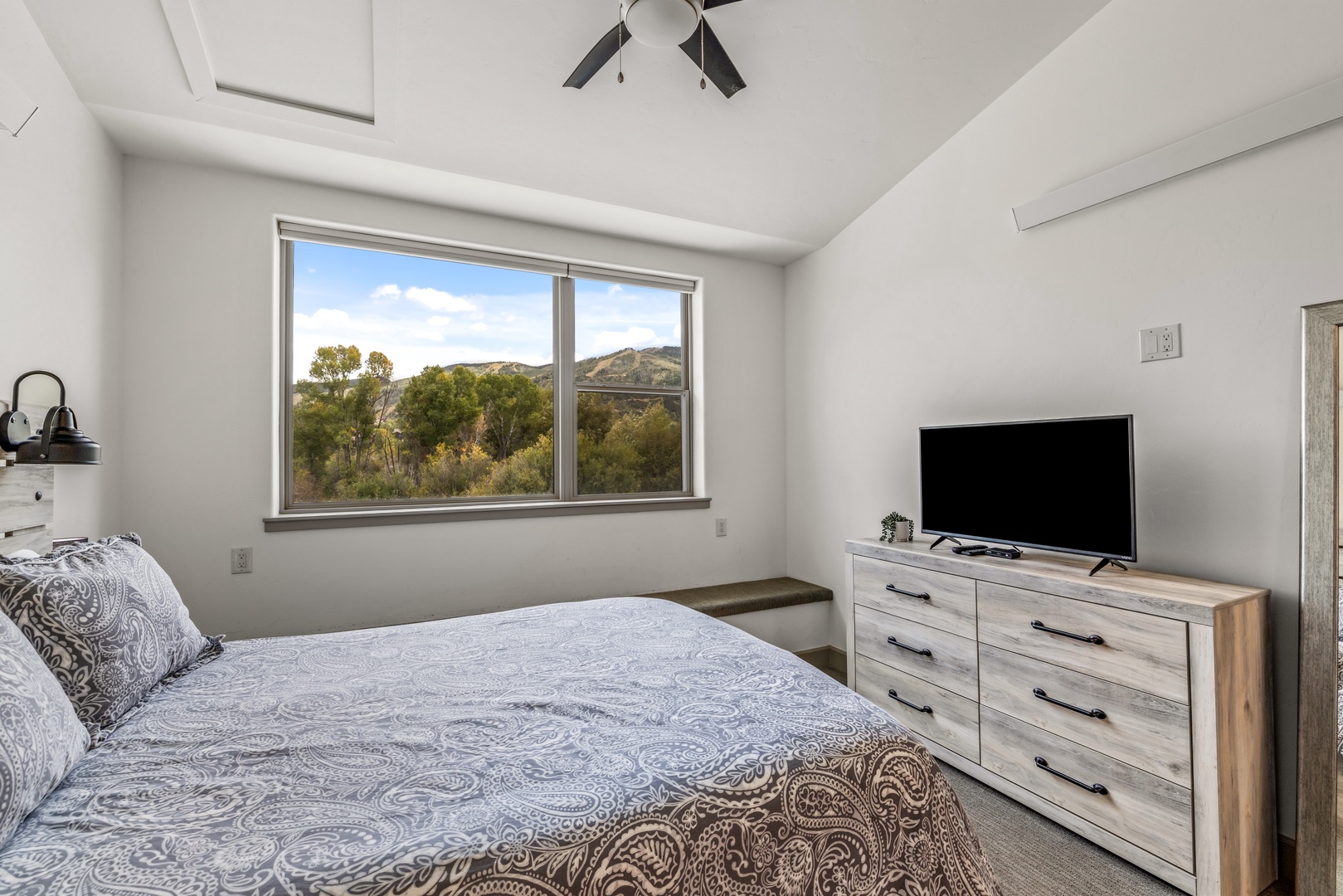 Wake up to serene desert views framed by your window, where rolling hills and native trees greet you each morning. This peaceful bedroom offers natural light, rustic furnishings, and a private retreat from everyday life.