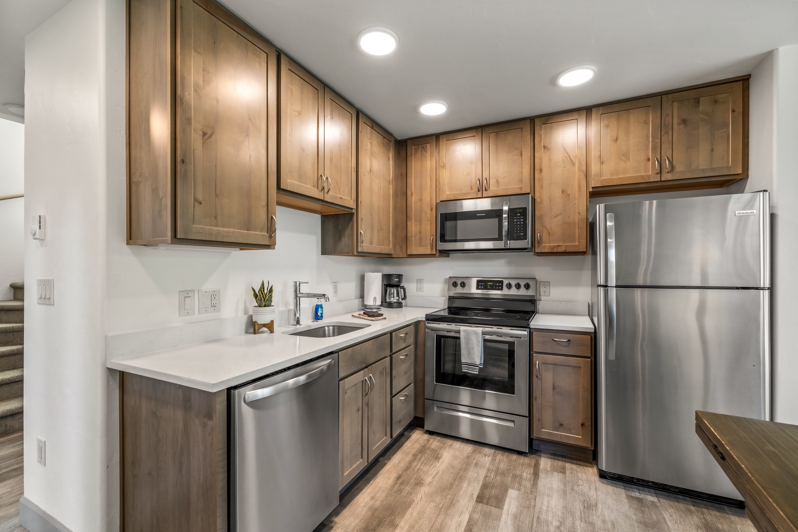 Your fully equipped kitchen features stainless steel appliances, warm wood cabinetry, and modern finishes—everything you need to prepare a homemade meal or morning coffee in comfort.