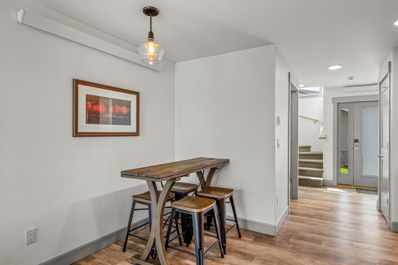 Gather at this charming high-top table where morning coffee and evening conversation feel right at home. Warm wood tones and soft lighting create the perfect spot for your meals and moments together.