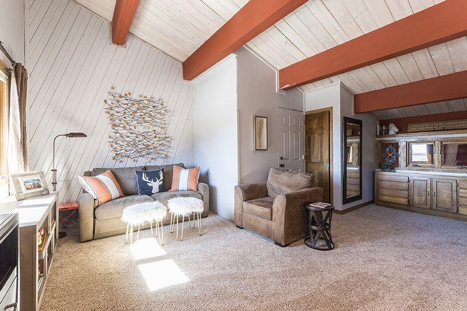 Kick back on the cozy sofa or armchair beneath bright beamed ceilings—your perfect spot to unwind after a day of adventure.