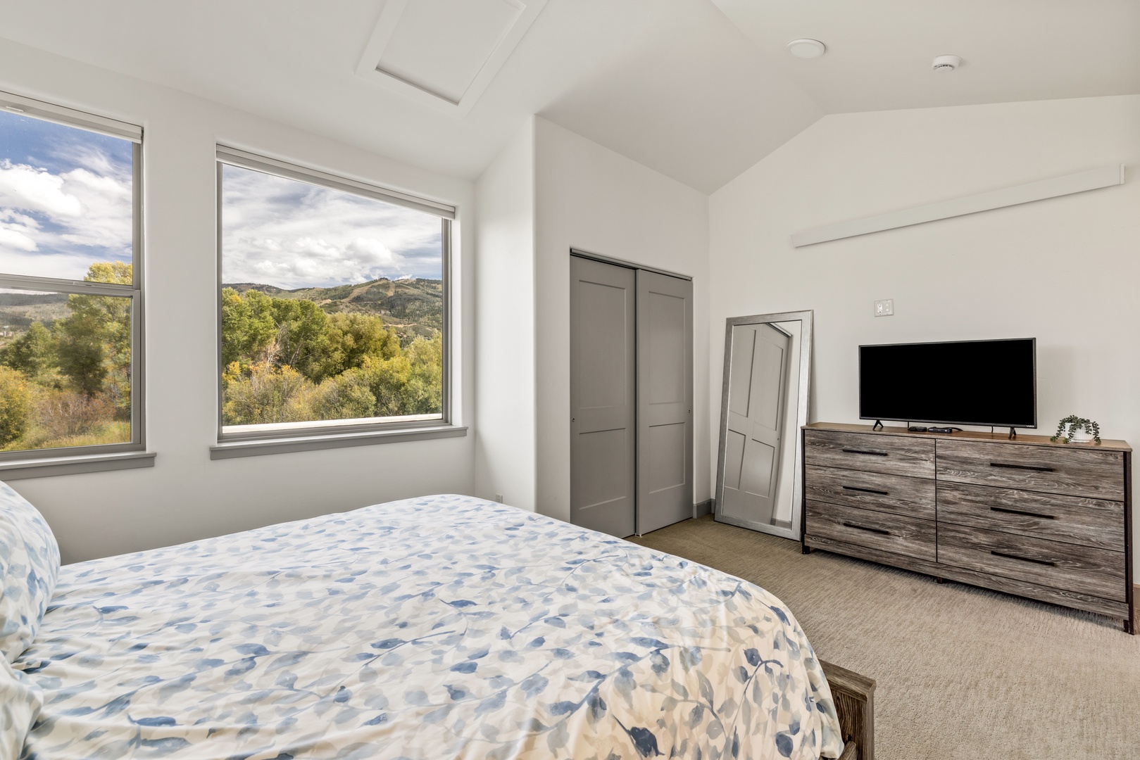 Wake to stunning mountain vistas framed by large windows that fill your bedroom with natural light and gorgeous scenery, creating a peaceful retreat with modern comfort and style.