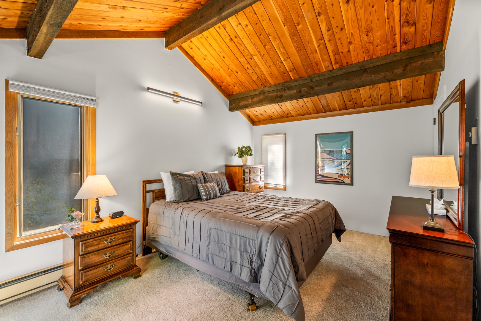 Slip into relaxation beneath soaring vaulted ceilings of warm pine, where rustic beams and plush bedding create your cozy mountain retreat.