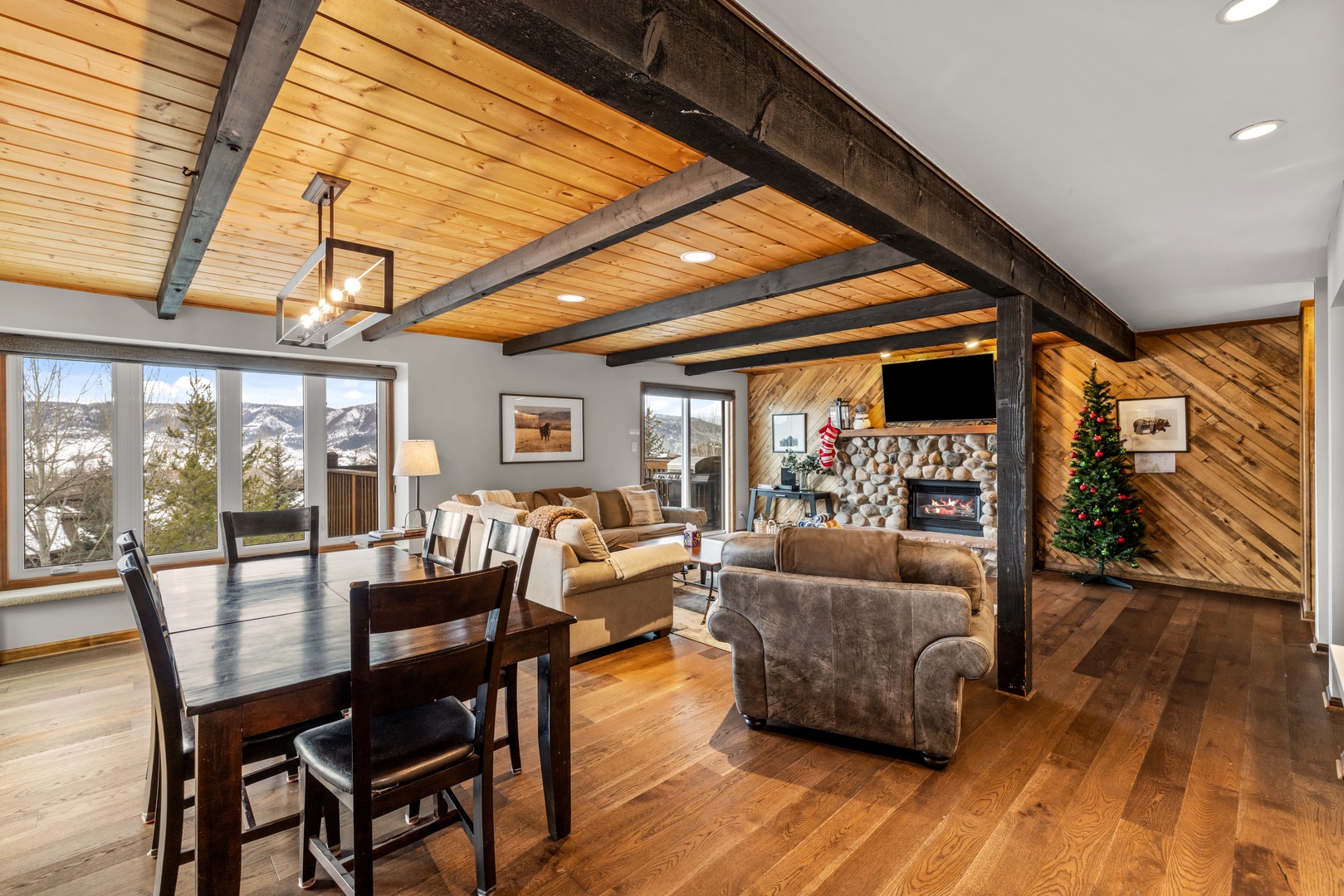 Cozy up in this stunning great room where rustic beams frame mountain views and a crackling fireplace creates the perfect alpine retreat.