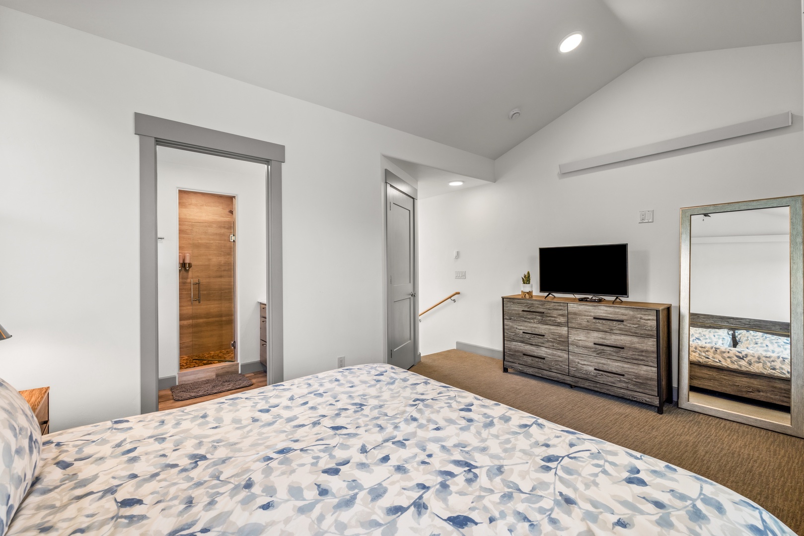 Step into your peaceful bedroom retreat, where soft carpets and modern touches create the perfect space to unwind. The sleek TV and stylish furniture set the scene for cozy evenings in.