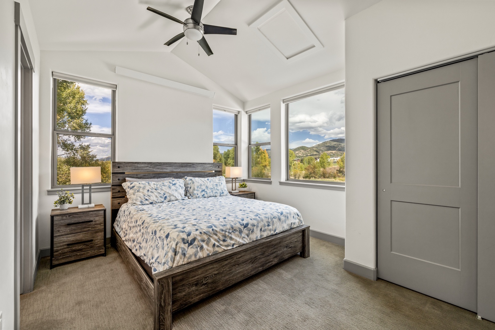 Wake up to stunning mountain views framing your bed. Your peaceful retreat features soaring vaulted ceilings, a ceiling fan for comfort, and generous windows that flood the space with natural light.