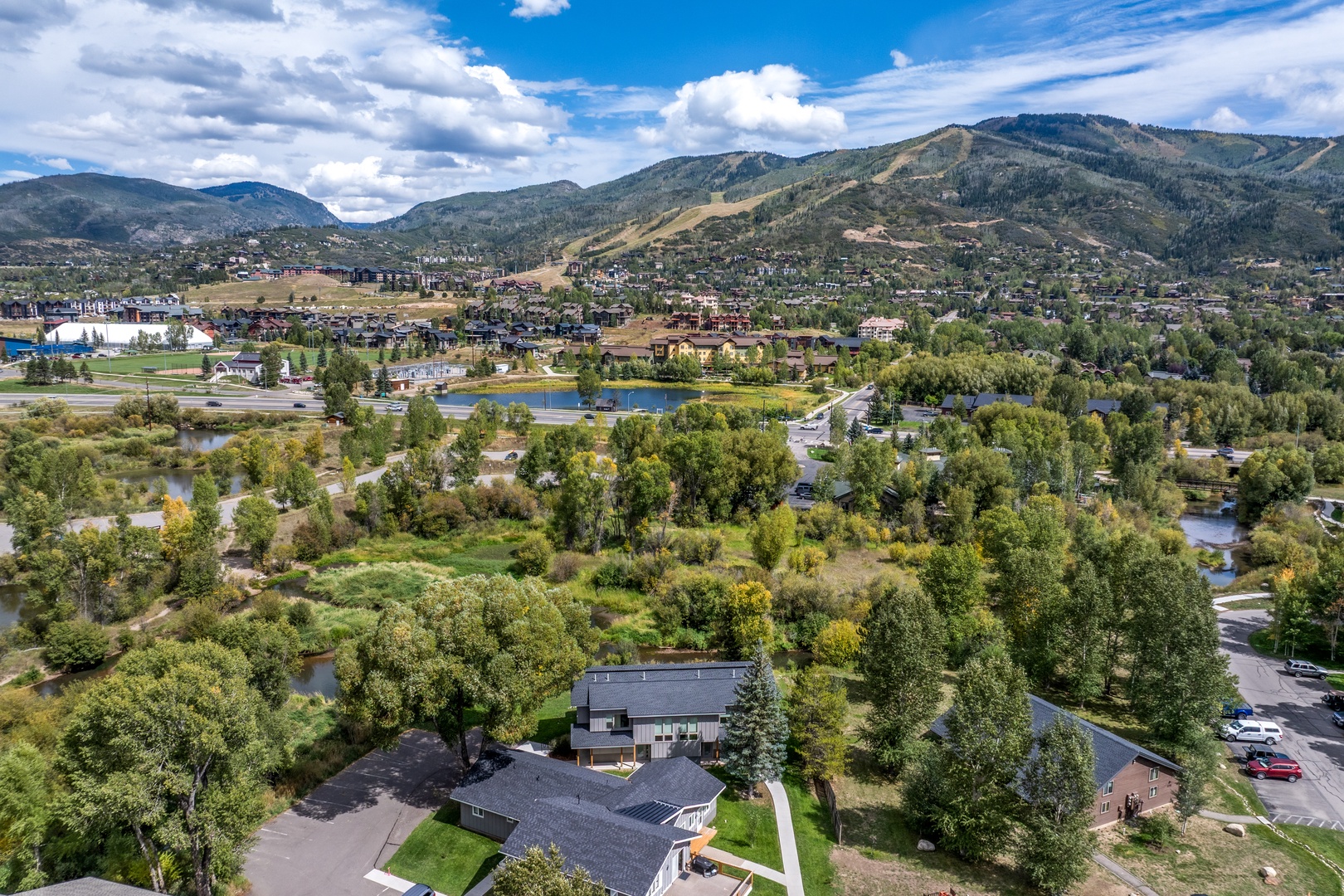 Aerial view of the property nestled in a scenic mountain valley, surrounded by natural landscape and community amenities.