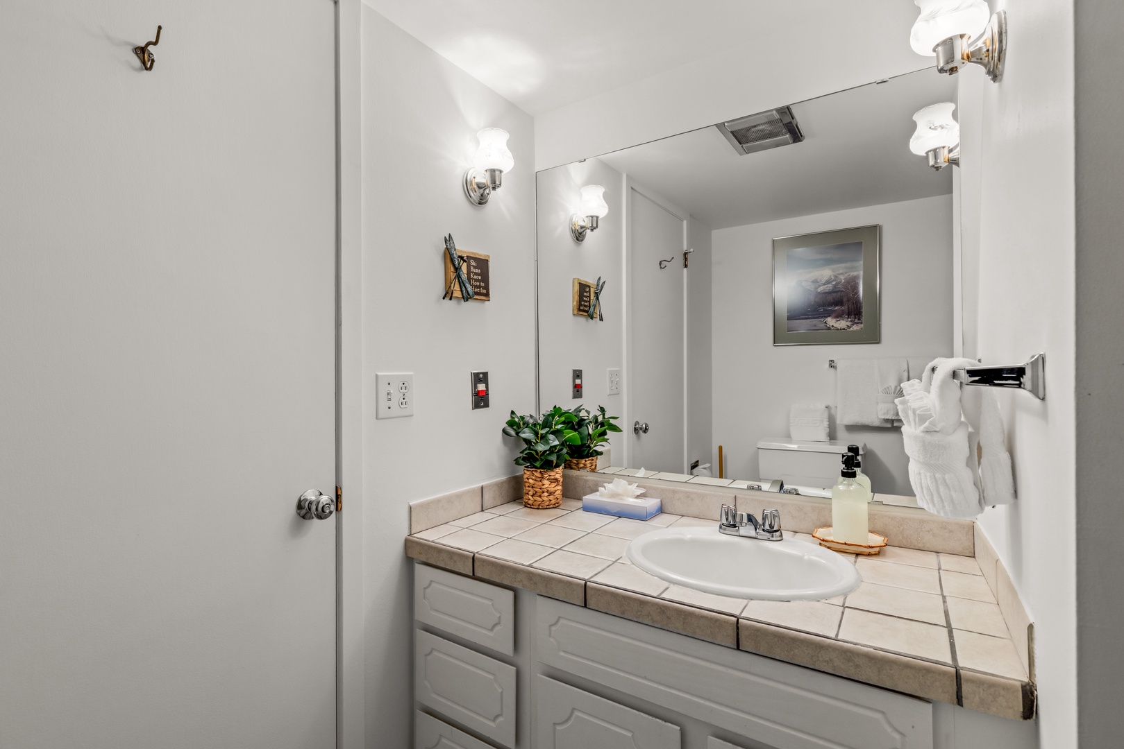 Step into a bright, thoughtfully designed bathroom where everything is arranged with your comfort in mind—plush towels, warm lighting, and thoughtful touches await.