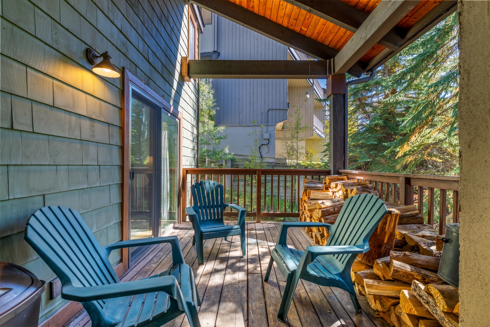 Step onto your private deck, where cozy seating awaits beneath soaring wood-beamed ceilings. Firewood is stacked and ready for those crisp mountain evenings, while dappled sunlight filters through the pines.