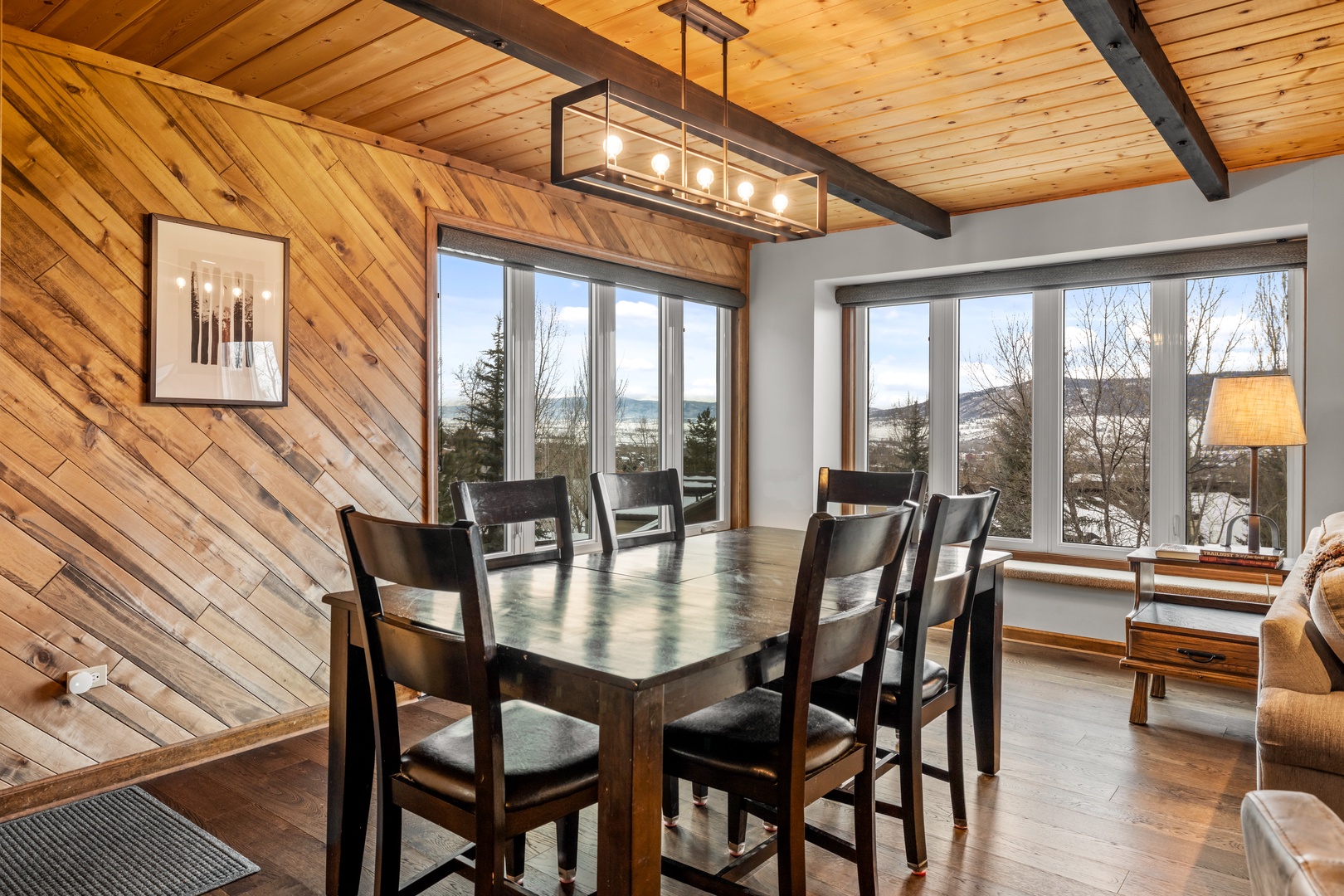Gather around your warm wood dining table while soaking in stunning mountain views through floor-to-ceiling windows.