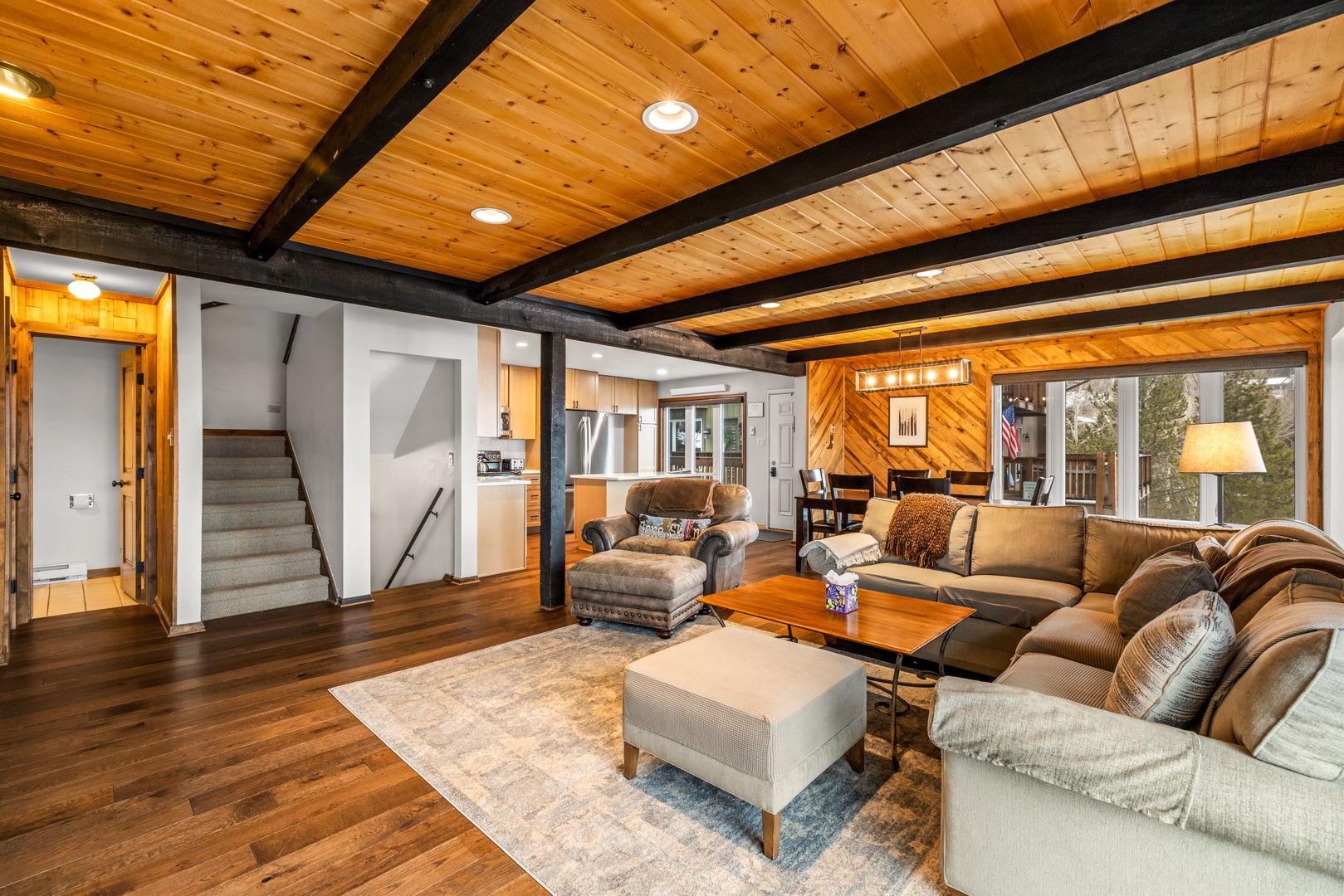 Relax in your spacious living area with exposed beams, cozy seating, and warm wood details that create the perfect mountain retreat atmosphere.