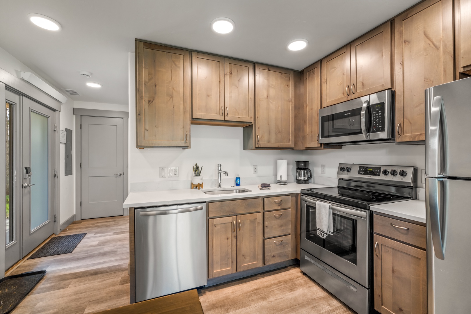 Your stylish kitchen welcomes you with warm wood cabinetry, modern stainless appliances, and spotless white countertops—everything you need to cook, gather, and feel right at home.