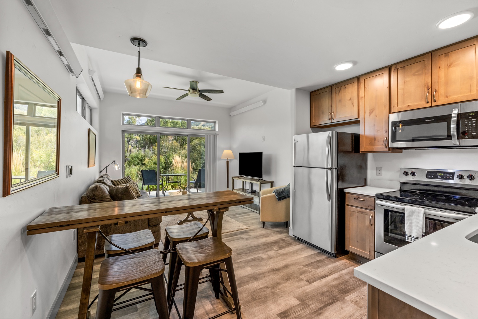 Step into this sunlit open-concept retreat where your kitchen, dining, and living areas flow seamlessly together. Natural light pours through floor-to-ceiling windows that frame lush garden views, inviting you to unwind in comfort and style.
