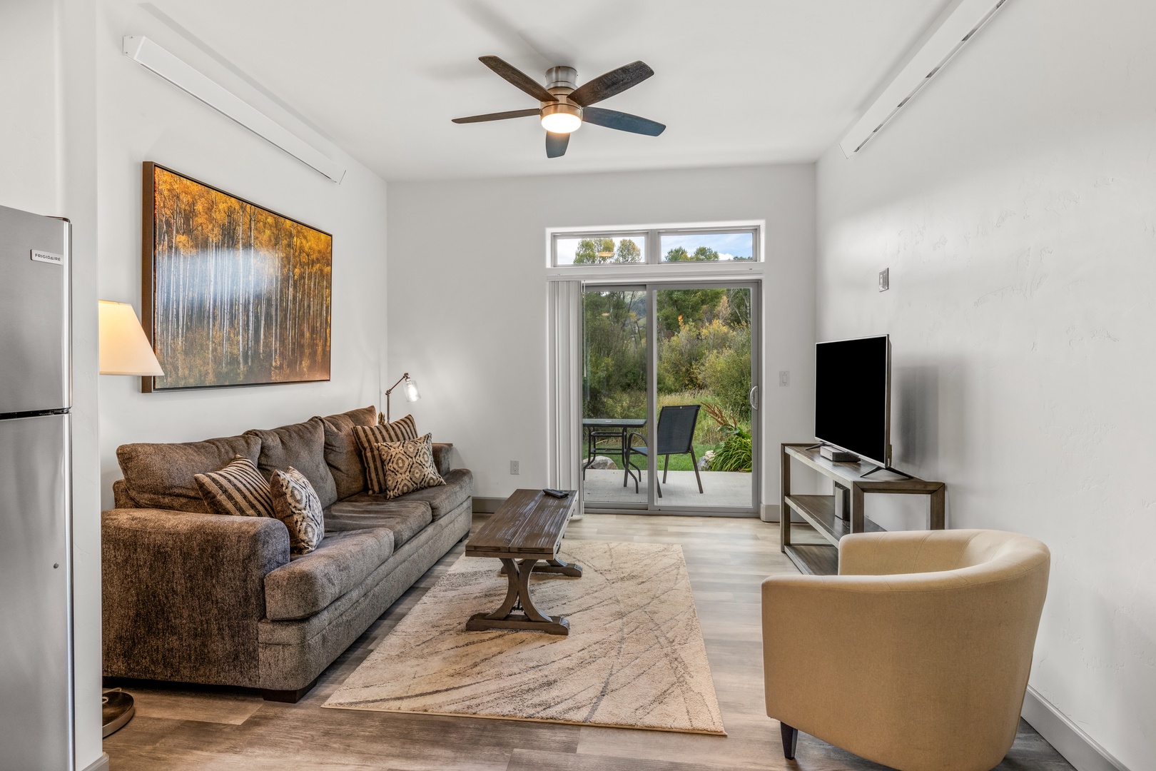 Relax in this bright, airy living room with plush seating, a peaceful garden view, and all the comforts of home waiting for you.
