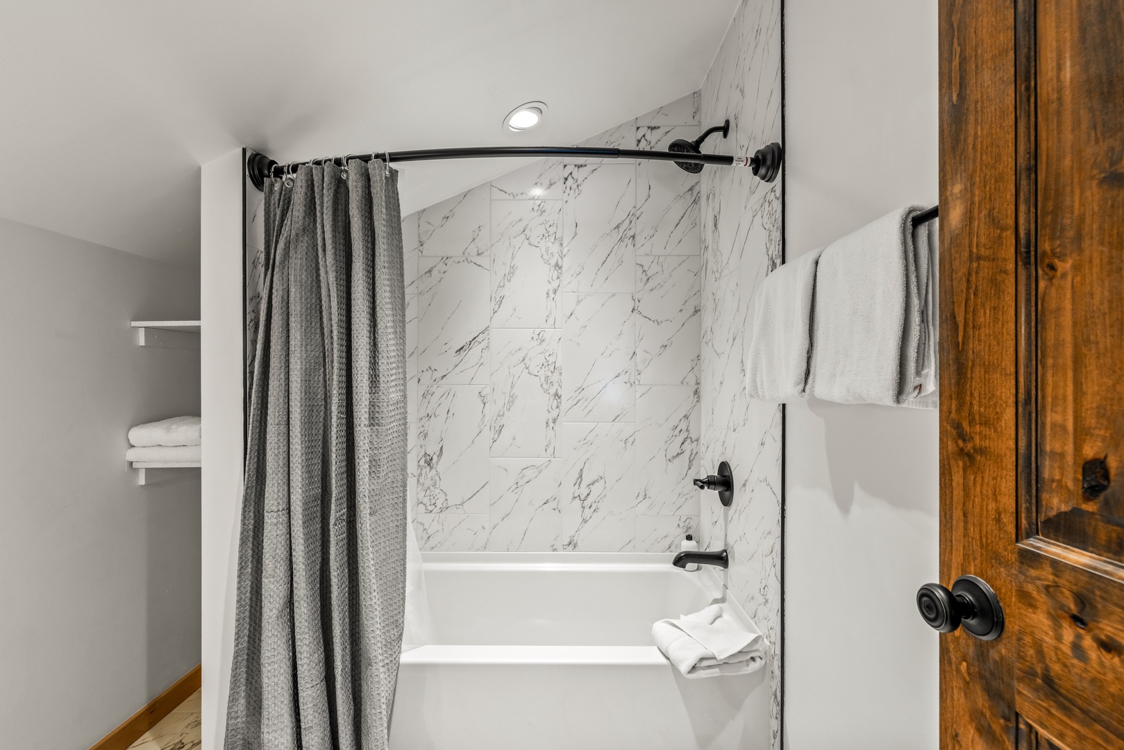Your elegant marble-walled tub awaits after a day of adventures, with plush towels ready for pure relaxation.