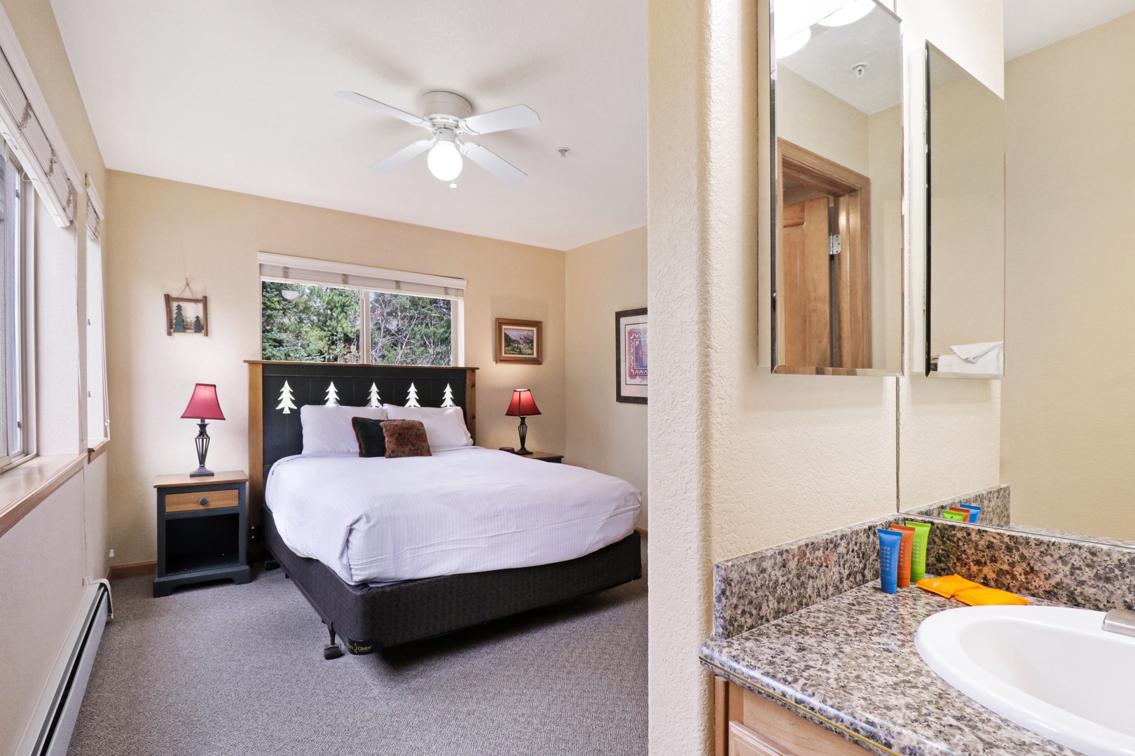 Rest easy in your cozy bedroom with a plush bed, warm wood tones, and a ceiling fan to keep you comfortable. The en-suite bathroom features granite counters and thoughtful touches to make you feel at home.