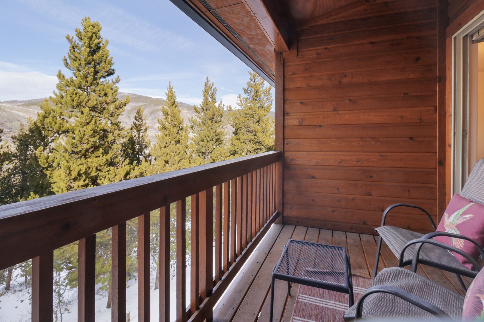 Step onto your private balcony and breathe in crisp mountain air while enjoying stunning forest views from your cozy seating area.