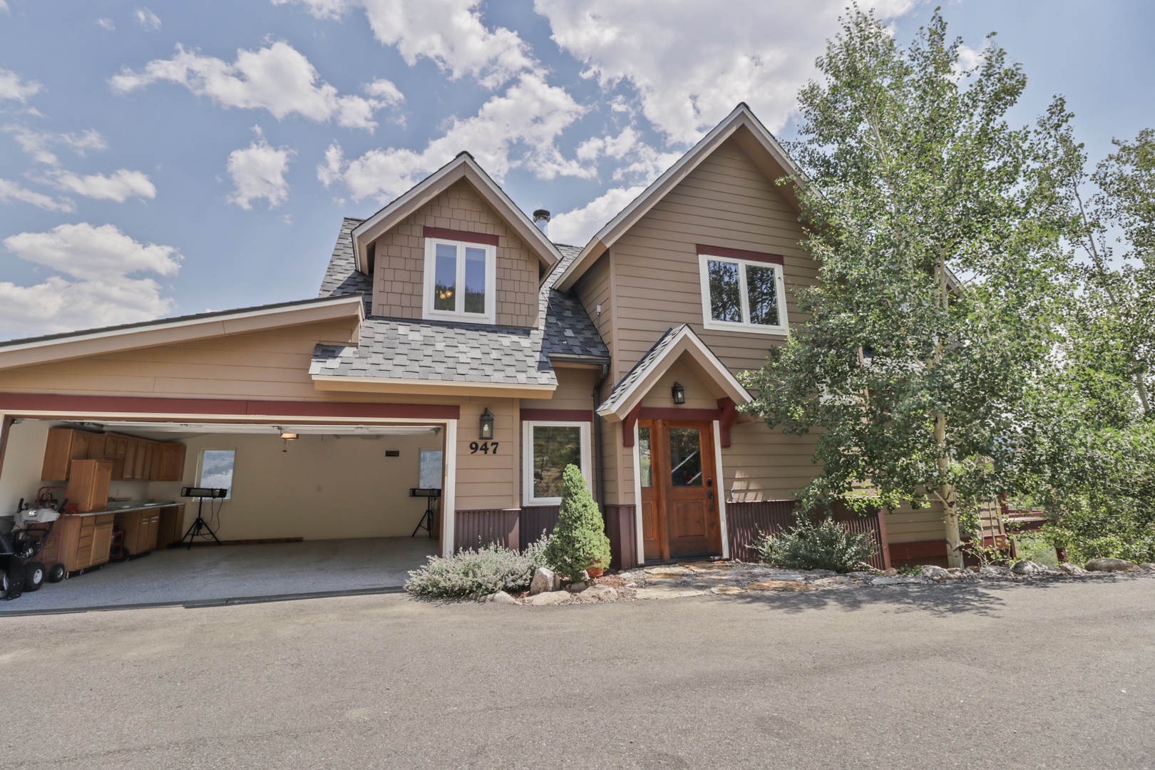 Charming mountain retreat with warm wood accents, twin gabled rooflines, and serene natural surroundings. Unit 947 welcomes guests with a cozy covered entrance and convenient garage access.