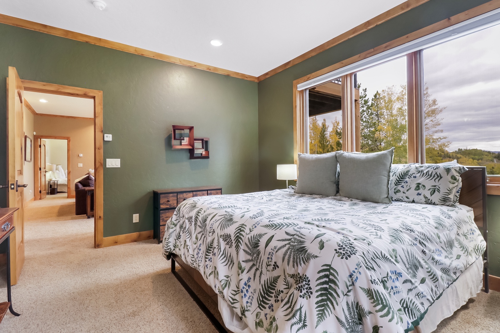 Wake up to treetops and natural light streaming through your oversized bedroom window, with calming sage tones and nature-inspired linens that bring the outdoors inside for your perfect retreat.