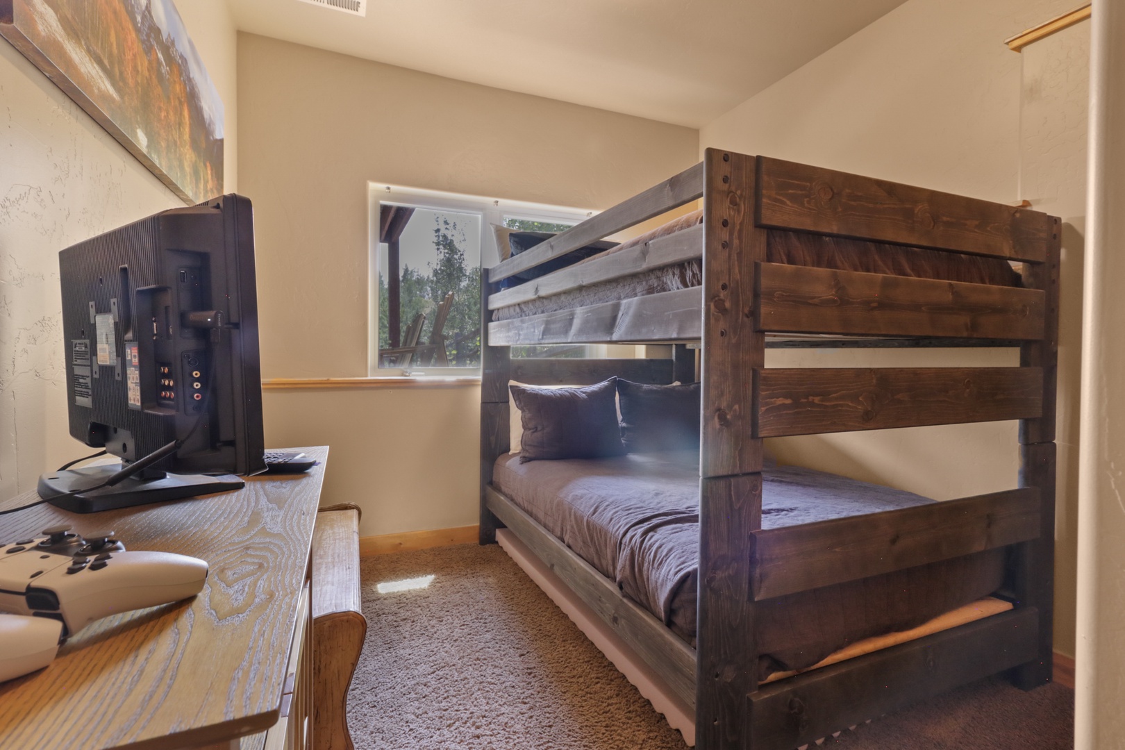 Your kids will love this cozy bunk room with rustic wood-framed beds and entertainment ready to go—perfect for settling in after a day of adventure.