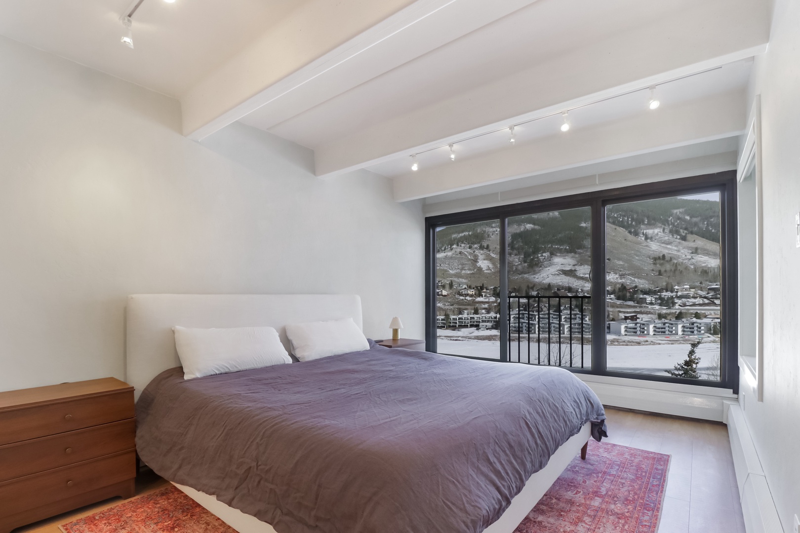 Wake up to stunning mountain views from your cozy bedroom, where exposed beams and modern comfort create the perfect alpine retreat.