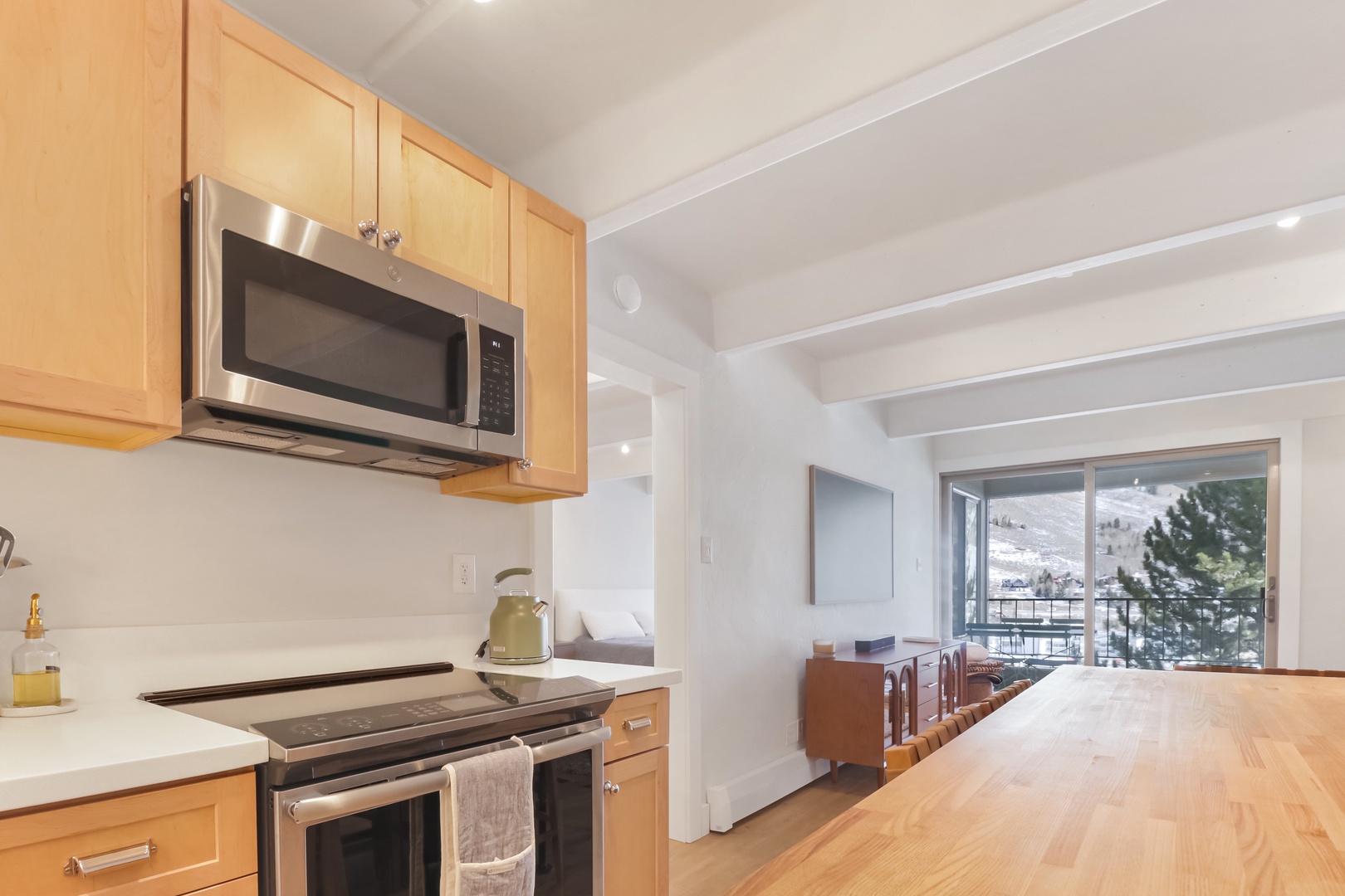 Your fully equipped kitchen features modern appliances and stunning mountain views from the dining area's large windows.