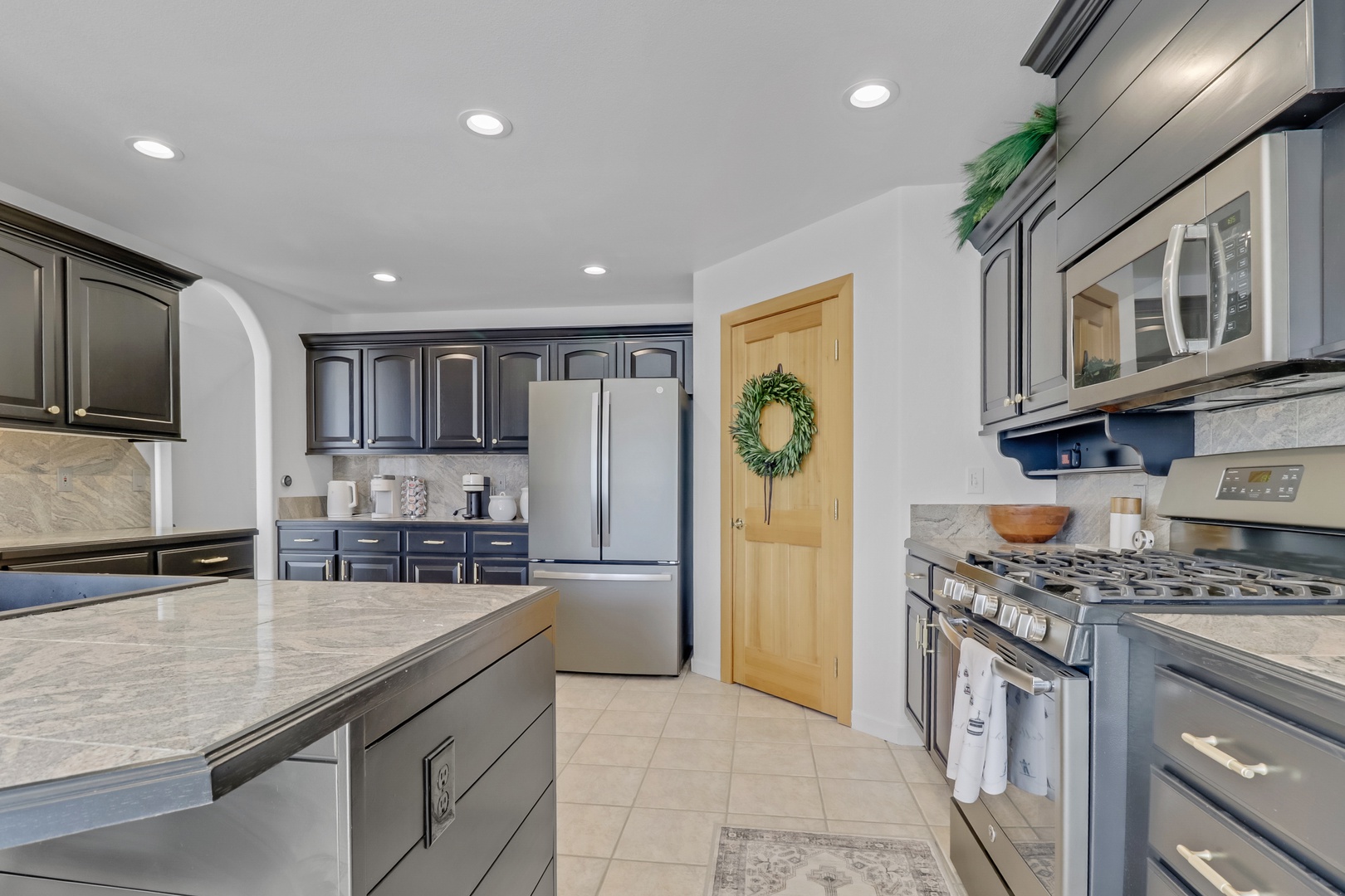 Your gourmet kitchen features sleek black cabinets, marble counters, and stainless appliances—perfect for creating memorable vacation meals together.