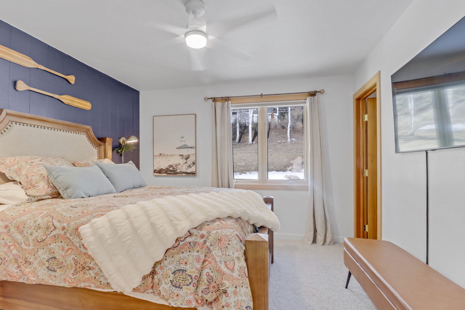 Your peaceful bedroom retreat features charming nautical touches and cozy linens, with snowy winter views just outside your window.