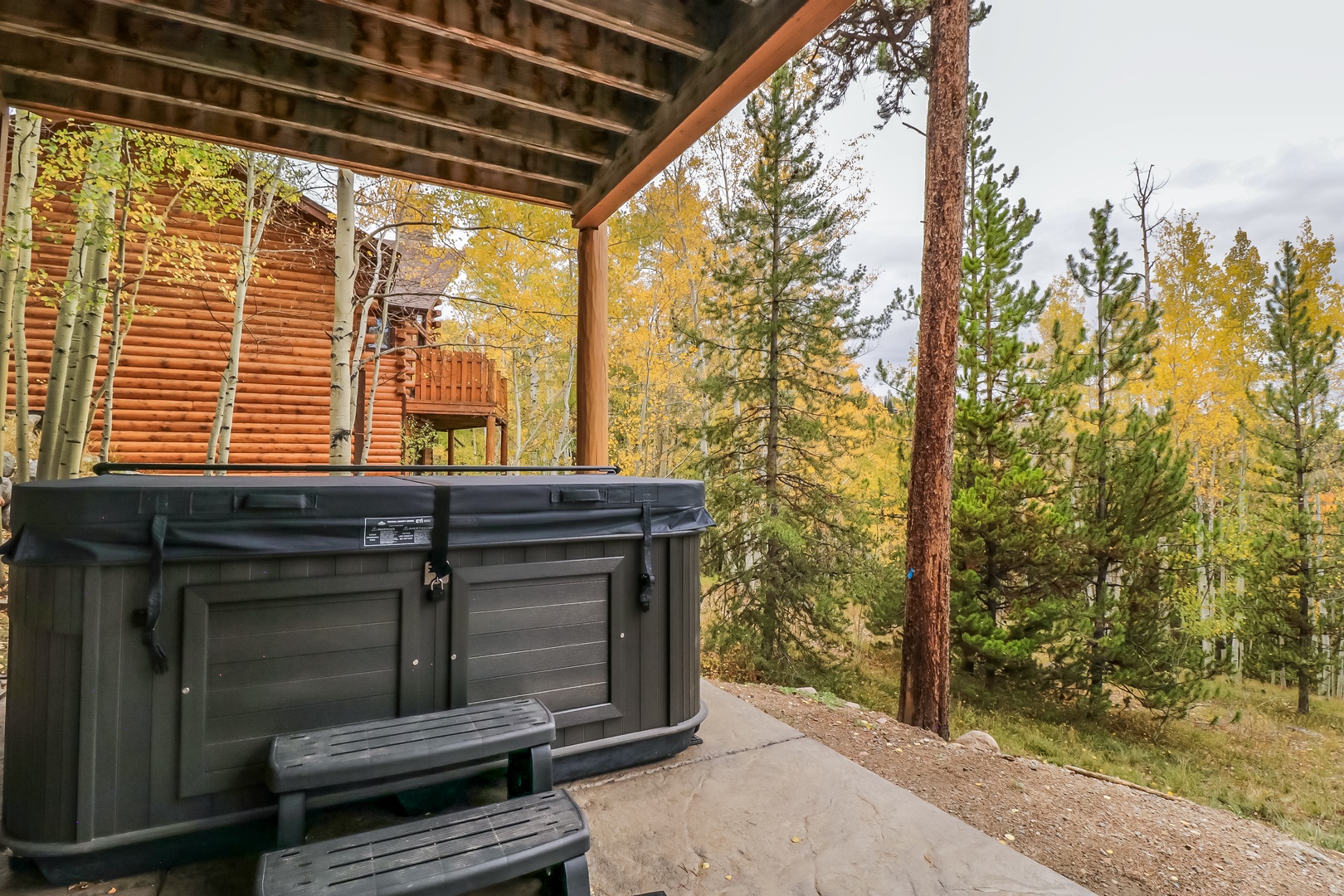 Soak in your private hot tub beneath the covered deck as golden aspens frame mountain views, inviting you to unwind in nature's serene embrace.