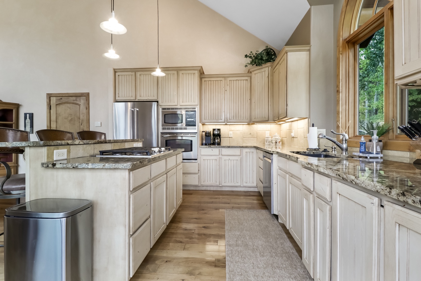 Step into this stunning gourmet kitchen with soaring vaulted ceilings, elegant granite countertops, and warm natural light streaming through tall windows. Your culinary adventures await in this beautifully appointed space.