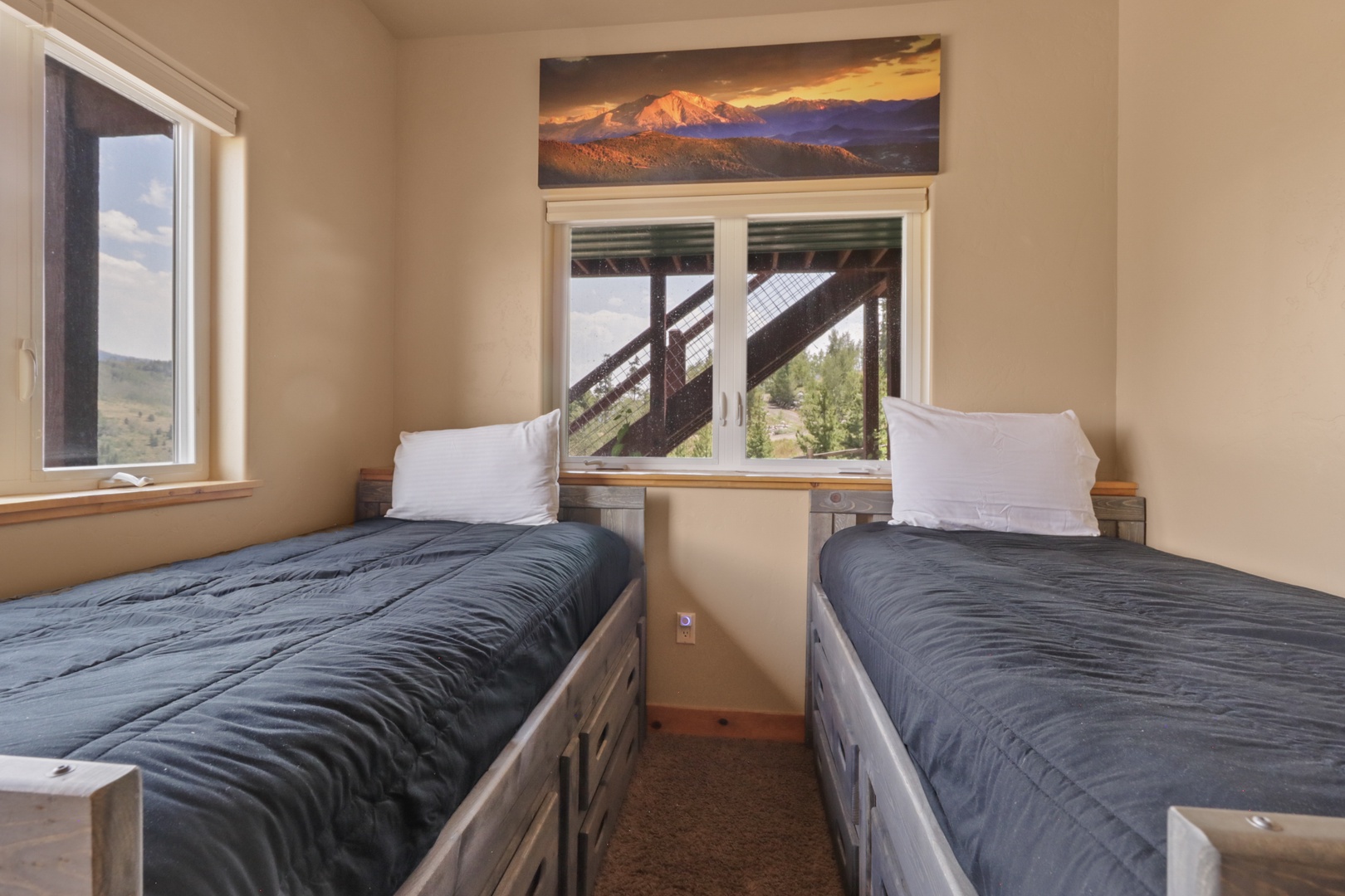 Wake up to natural light streaming through your windows, framing peaceful views of rolling hills and greenery. Two comfortable twin beds ensure a restful night's sleep in this cozy, inviting space.