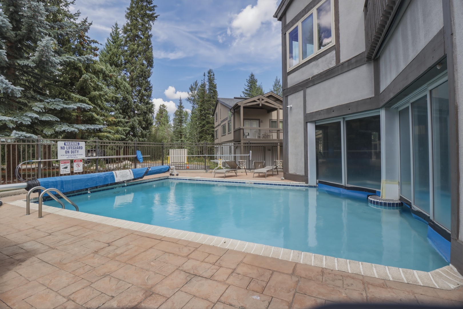 An inviting outdoor pool surrounded by tall pines and mountain scenery, offering a refreshing escape after your day exploring the area.