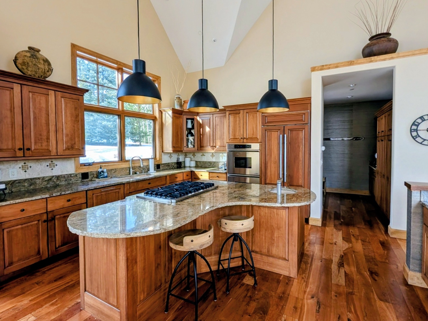 Open concept kitchen area featuring updated lighting and seating at the island