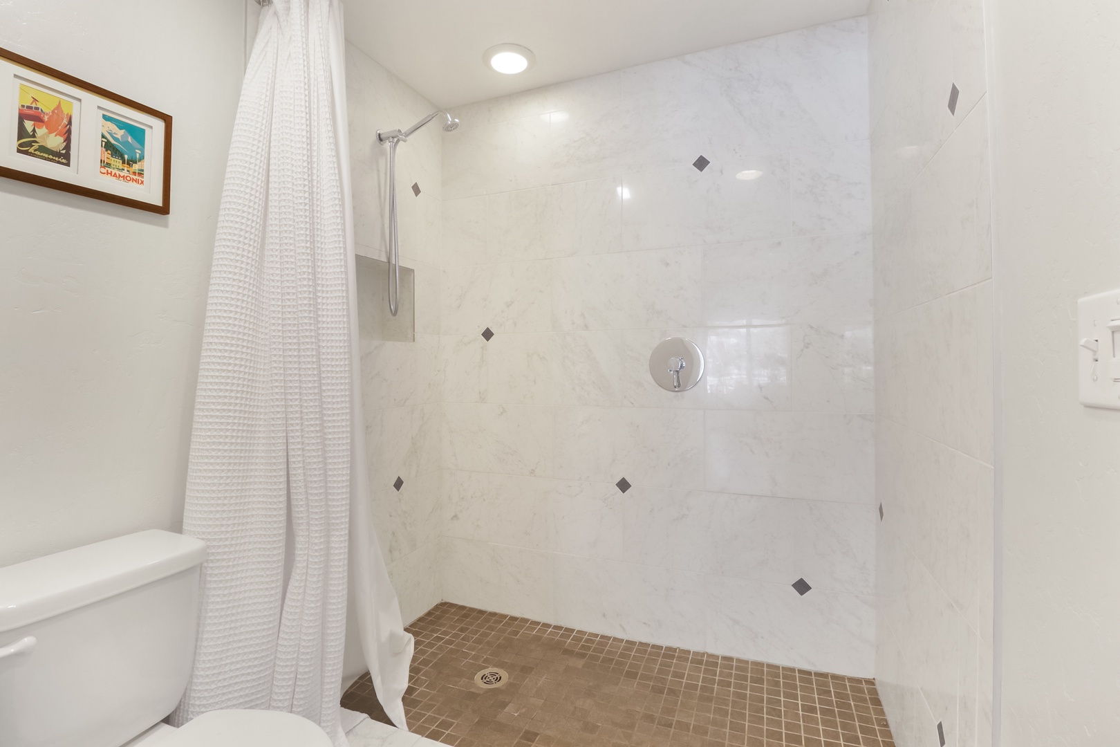 Refresh in your spacious tiled shower with rainfall head and convenient built-in bench for comfort.