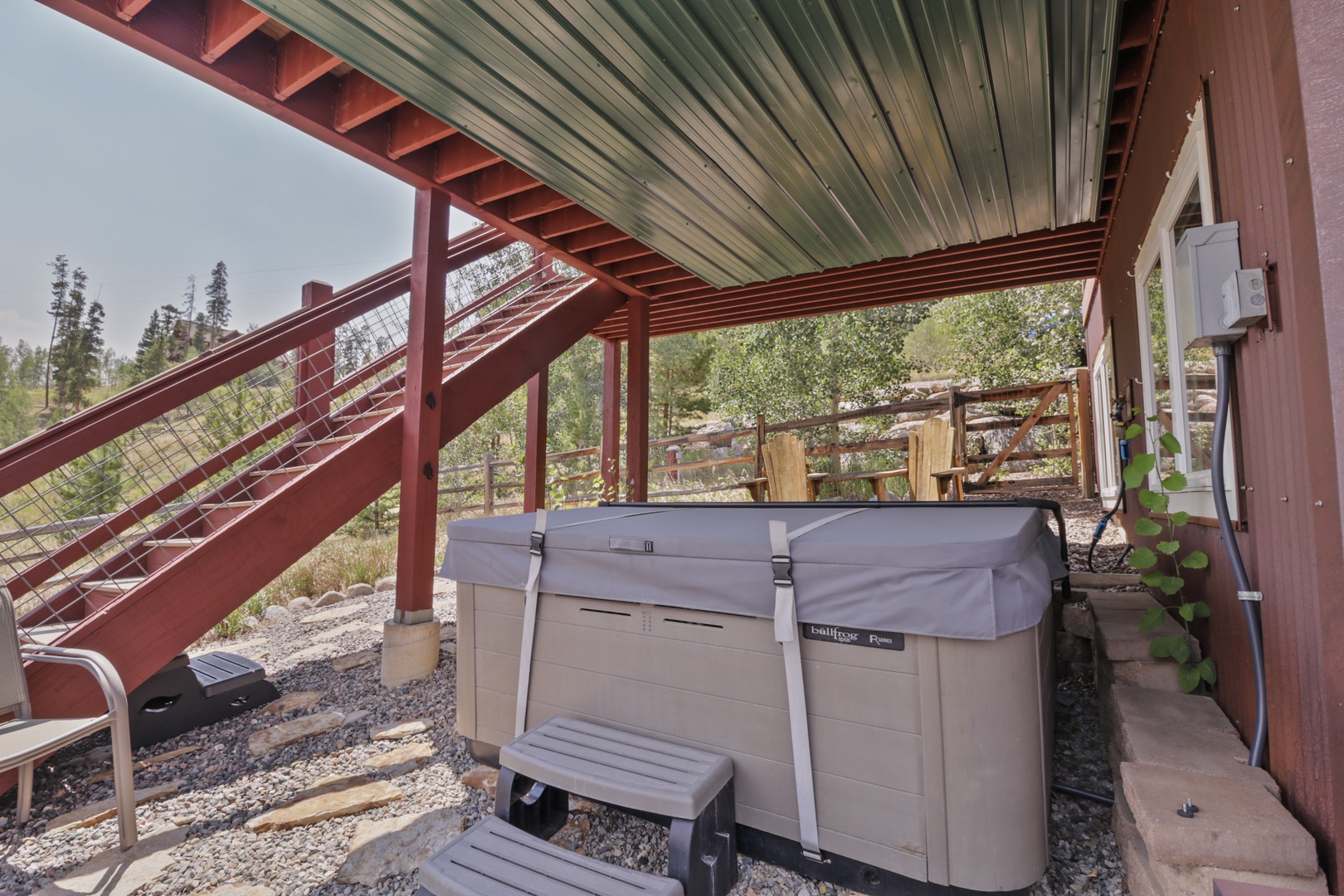 Step into your private covered patio with a soothing hot tub, framed by mountain pines and fresh air. This sheltered outdoor space invites you to unwind in nature's embrace.