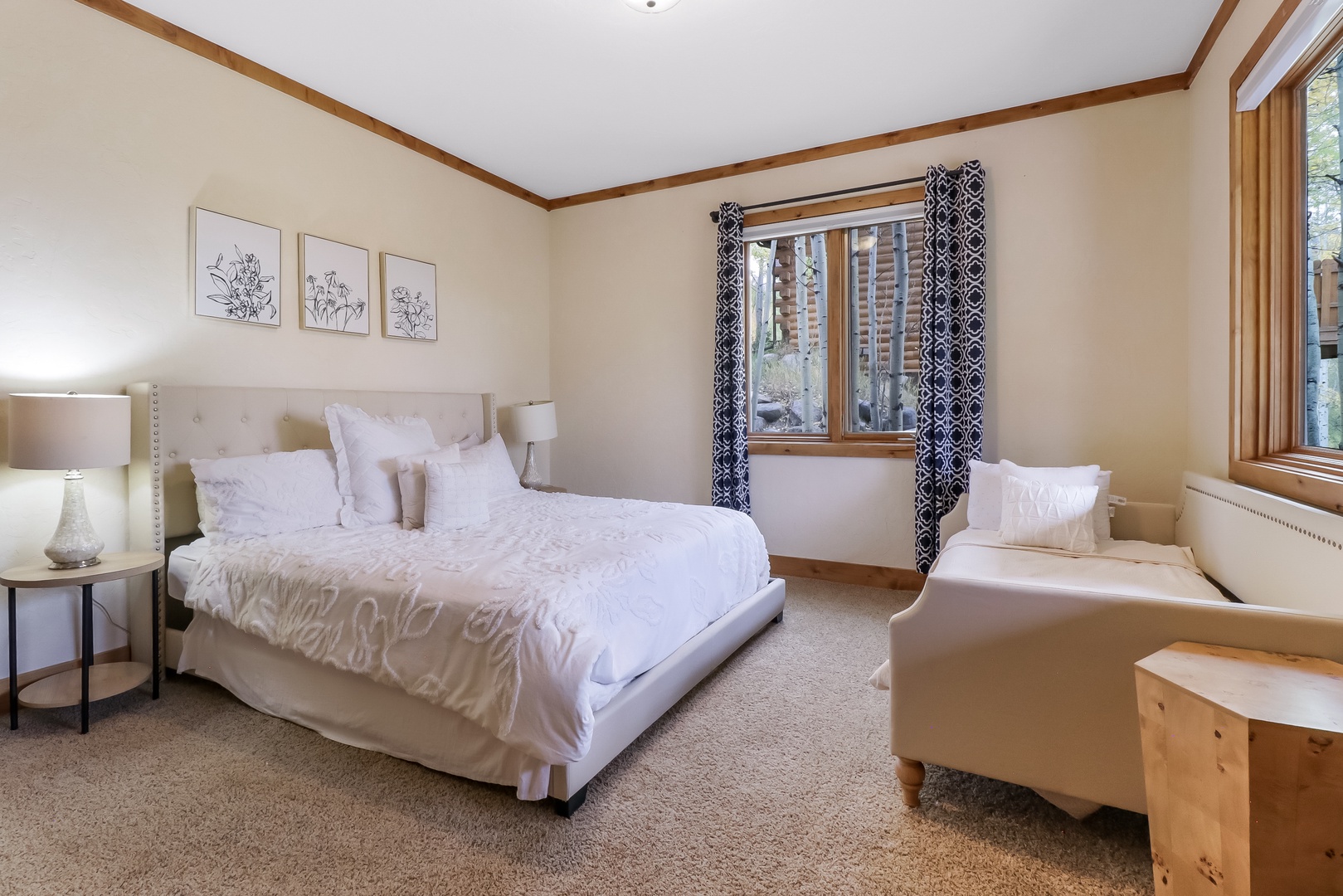 Drift off in this tranquil bedroom with soft linens, warm wood accents, and natural light streaming in. Your cozy chair by the window invites morning coffee or quiet reflection.
