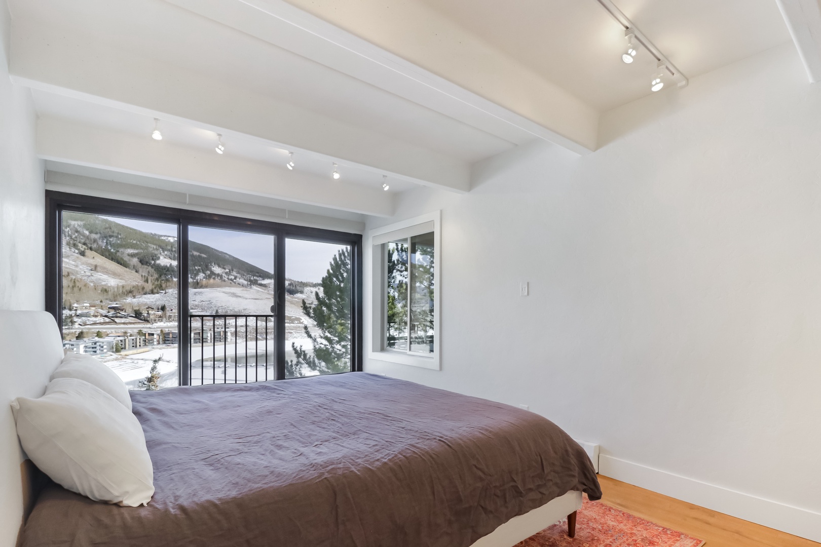 Wake up to stunning mountain views from your cozy bed, where snowy peaks frame your morning through floor-to-ceiling windows.