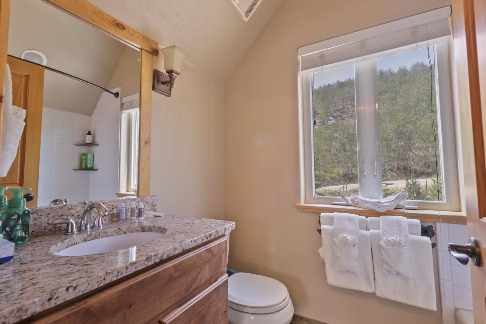Refresh in your private bathroom with natural light streaming through the window and thoughtful amenities ready for you.