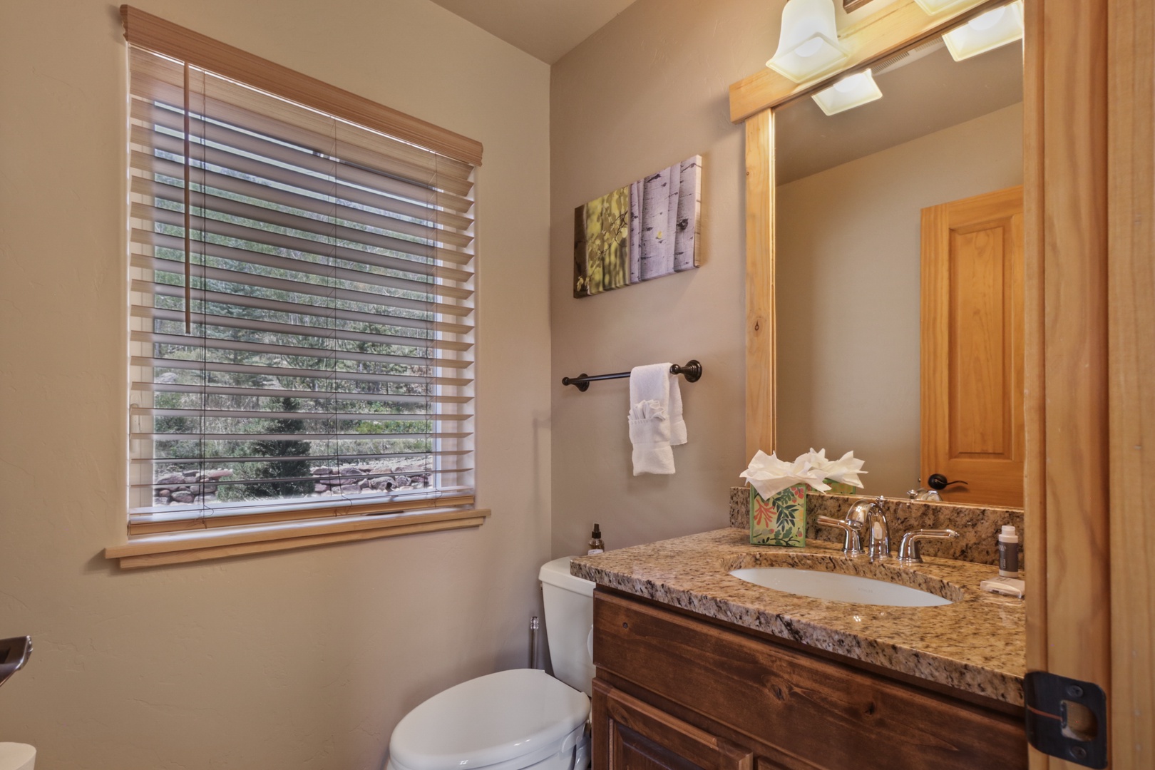 Freshen up in your bright bathroom with a granite vanity and natural light streaming through the window. Soft towels and thoughtful details await your arrival.