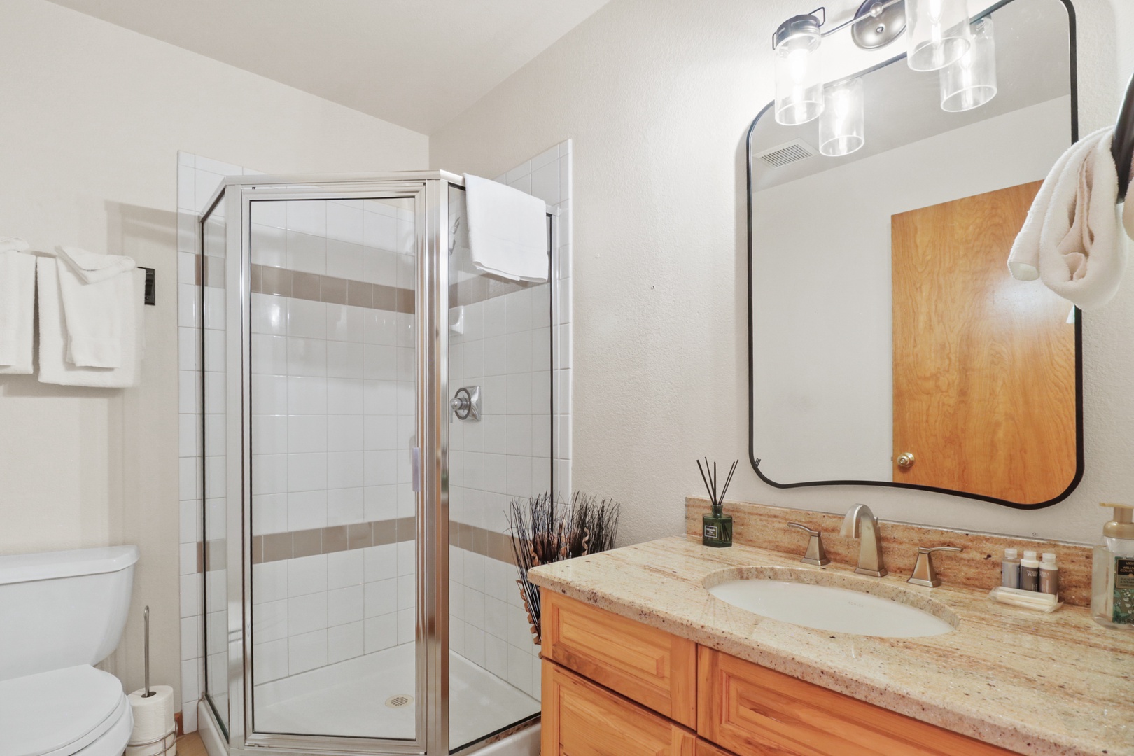Refresh in your private bathroom featuring a spacious glass shower, granite countertops, and modern fixtures with fluffy towels ready for you.