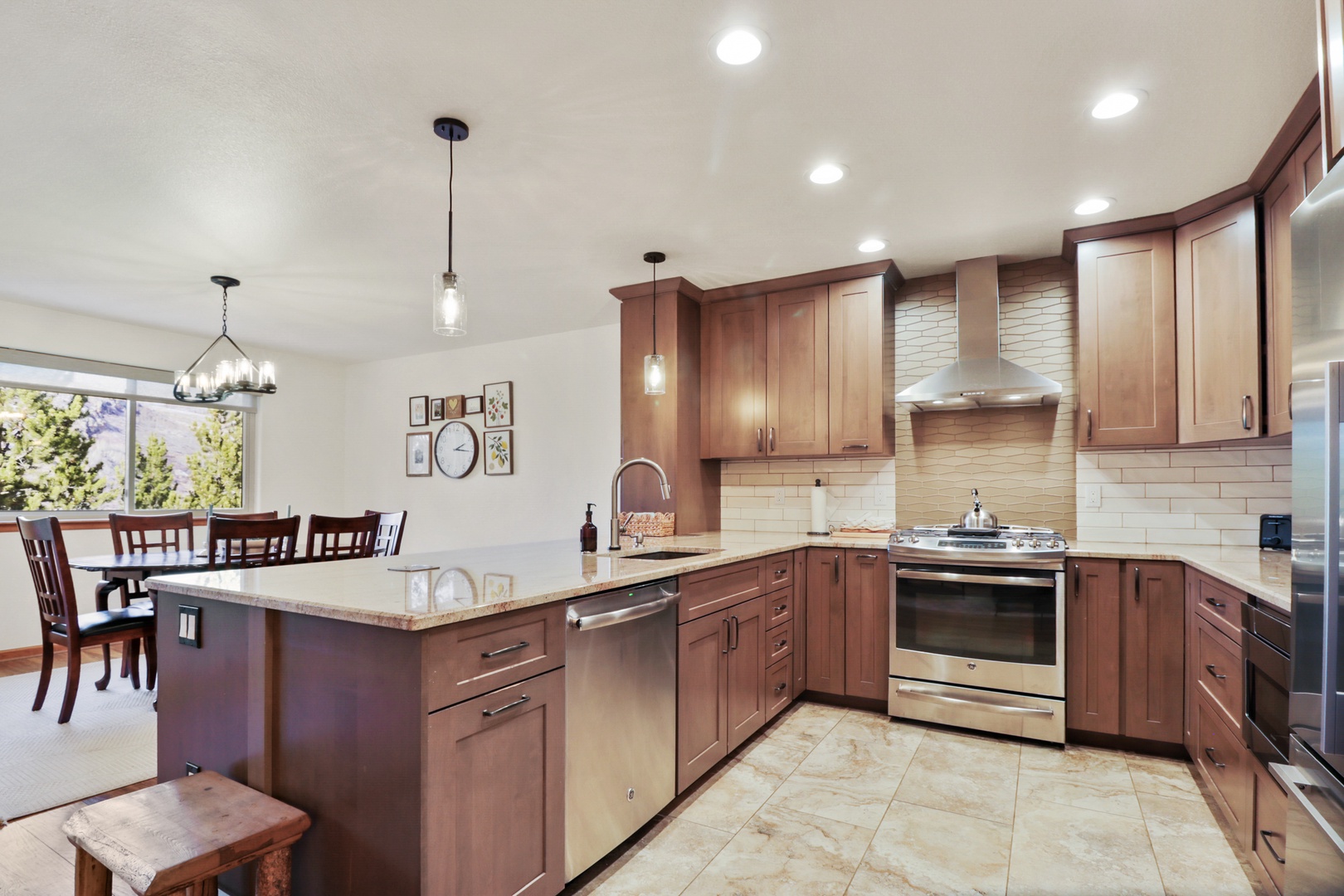 Your spacious kitchen invites culinary adventures with rich wood cabinets, granite counters, and top-tier appliances flowing into the bright dining area.