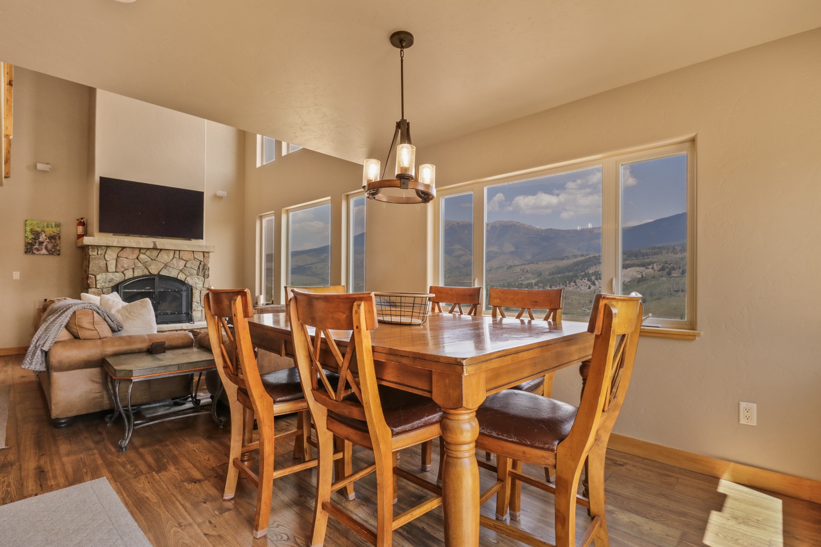 Enjoy meals with a stunning mountain view framed by expansive windows, while the open layout connects you to the cozy living space with its inviting fireplace.